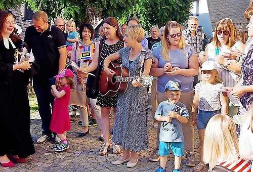Das Foto zeigt eine Gruppe von Menschen verschiedener Alter. Darunter die Pfarrerin Frau Pöhlmann in ihrem Talar.