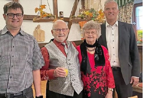 Dat Foto zeigt den Jubilar in der Mitte. Daneben steht eine ältere Frau und zwei Männer, darunter BGM Timo Ehrhardt. Sie alle lächeln in die Kamera. 