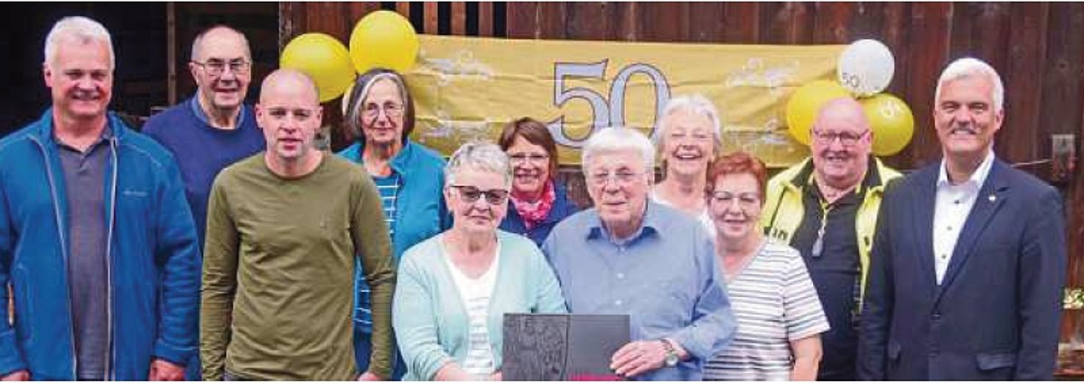 Eine Gruppe von Menschen verschiedenen Alters stehen zusammen und schauen in die Kamera. In der Mitte steht das Paar, das goldene Hochzeit feiert. Bürgermeister Timo Ehrhardt steht am rechten Bildrand.