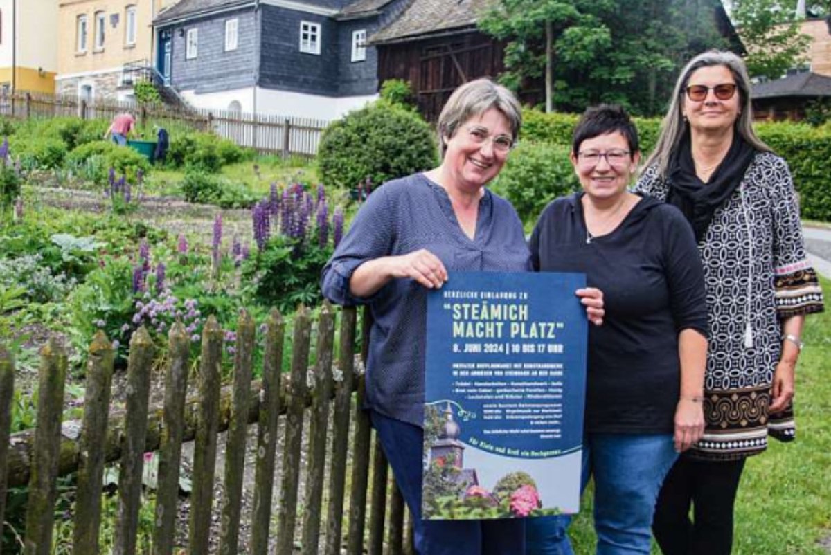 Drei Frauen stehen vor dem Garten in Steinbach an der Haide und halten ein Plakat in die Kamera.