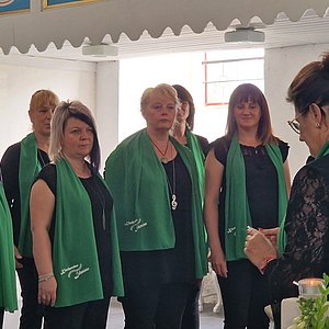 Das Foto zeigt den Lehestener Kirchenchor. Zu sehen sind neun Frauen des Chors. Sie tragen schwarze Kleidung und ein grünes Halstuch.